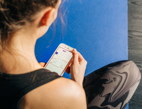 Young women using her mobile phone to track her period